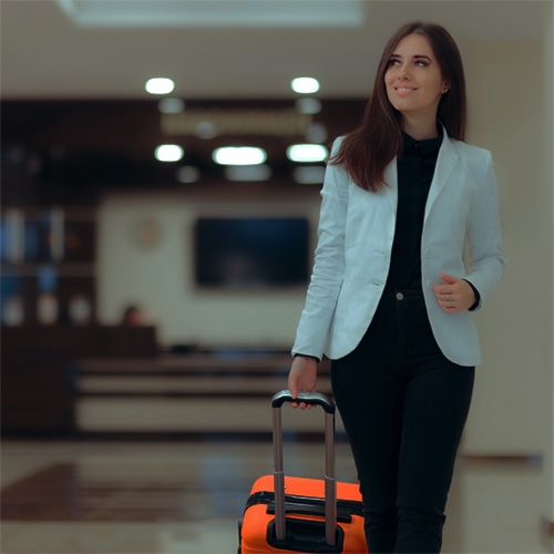 Woman pulling suitcase through hotel lobby